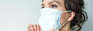 Physician adjusting surgical mask
